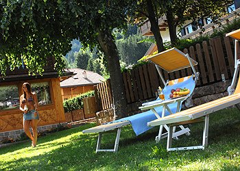 Residences a Moena. giardino attrezzato con lettini e giochi per i bambini
